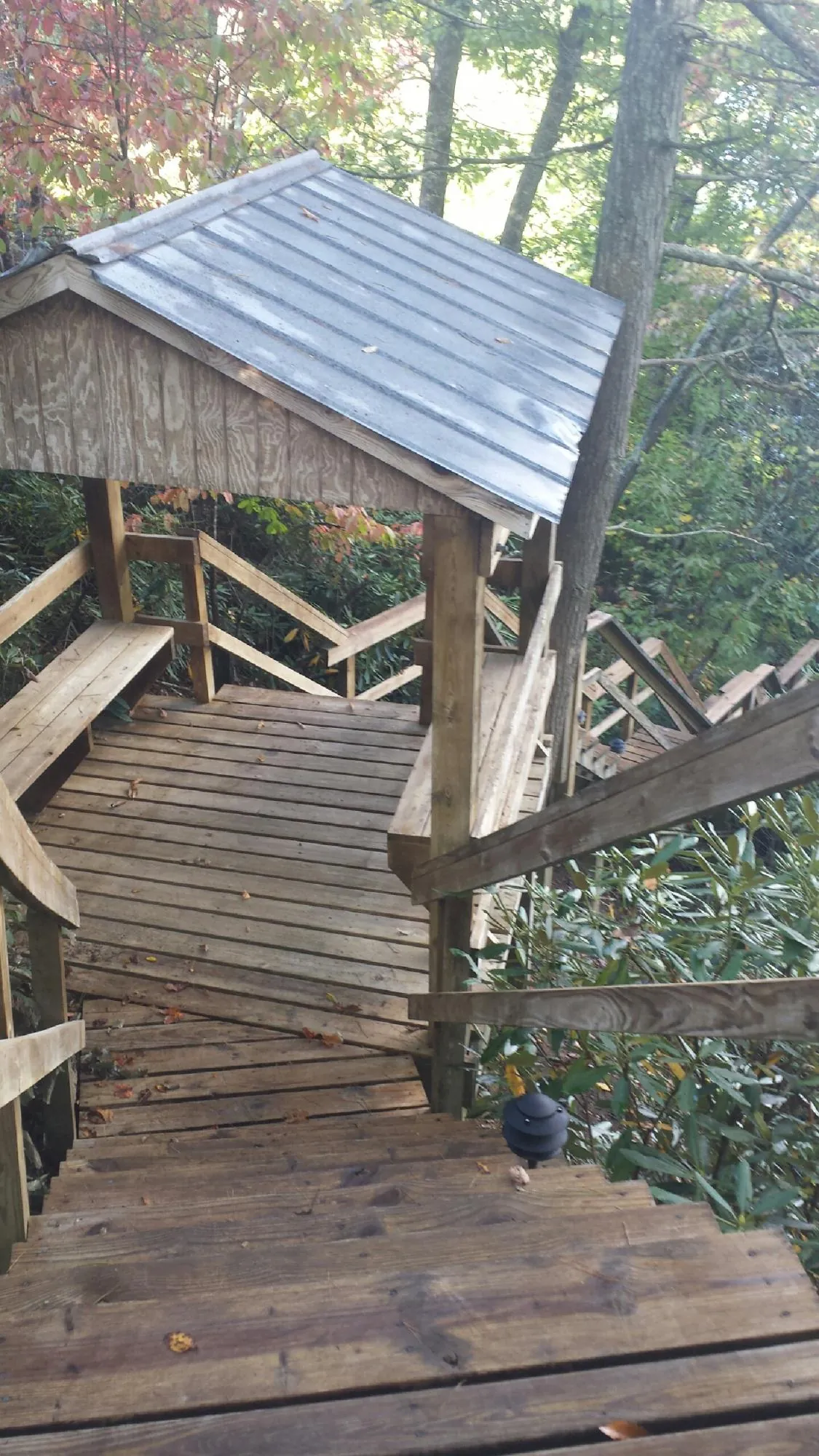 Metal roofed shelter over wooden steps on a wooded walkway — Skylight Repair & Installation work by our crew in Penn Run