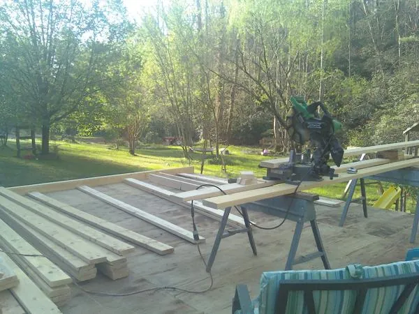Miter saw and framing lumber on a deck under construction in Penn Run