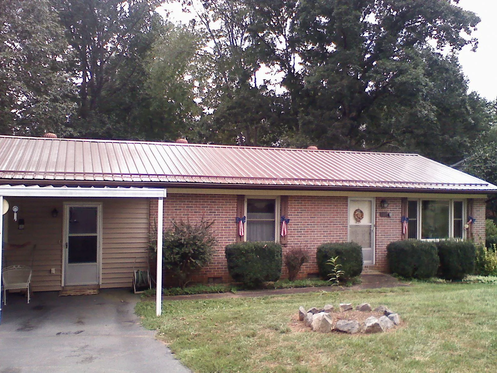 Bronze metal roof and carport on a brick ranch home — Roof Repair work by our crew in Penn Run